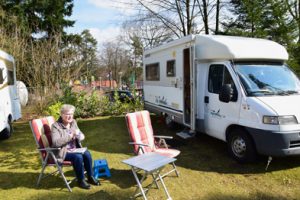 Loes geniet nog even van de zon bij de camper