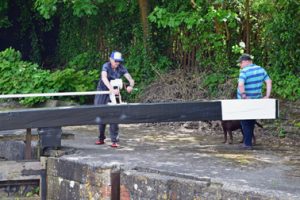 de schipper helpt de sluiswachter bij het zware werk
